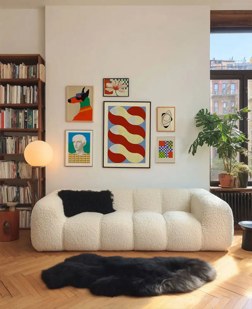 Kremowy, pluszowy sofa b&b italia o nowoczesnym designie i czarnym poduszką dekoracyjną.